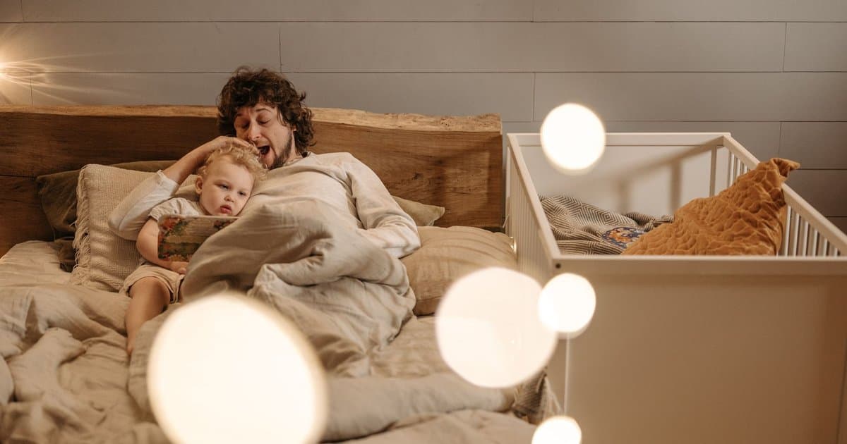 A father reads to his child at bedtime, illustrating how to engage reluctant readers with stories.