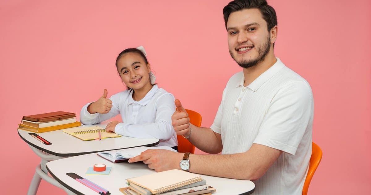 Teacher and student giving thumbs up at a desk, representing meaningful gifts that support classroom success.