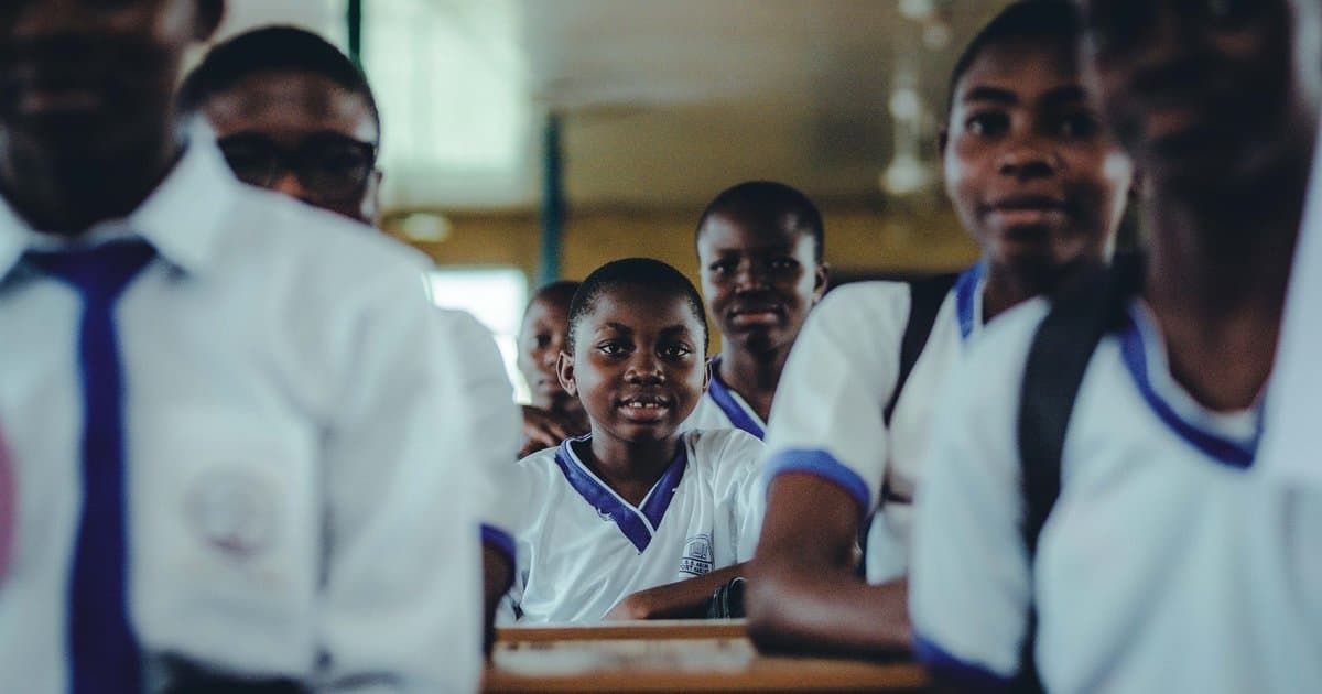 Classroom of uniformed students learning together, relating to inclusive educational activities for young learners.