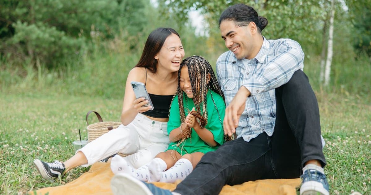 A family of mixed ages sharing a meal outdoors, demonstrating bonding through shared activities.
