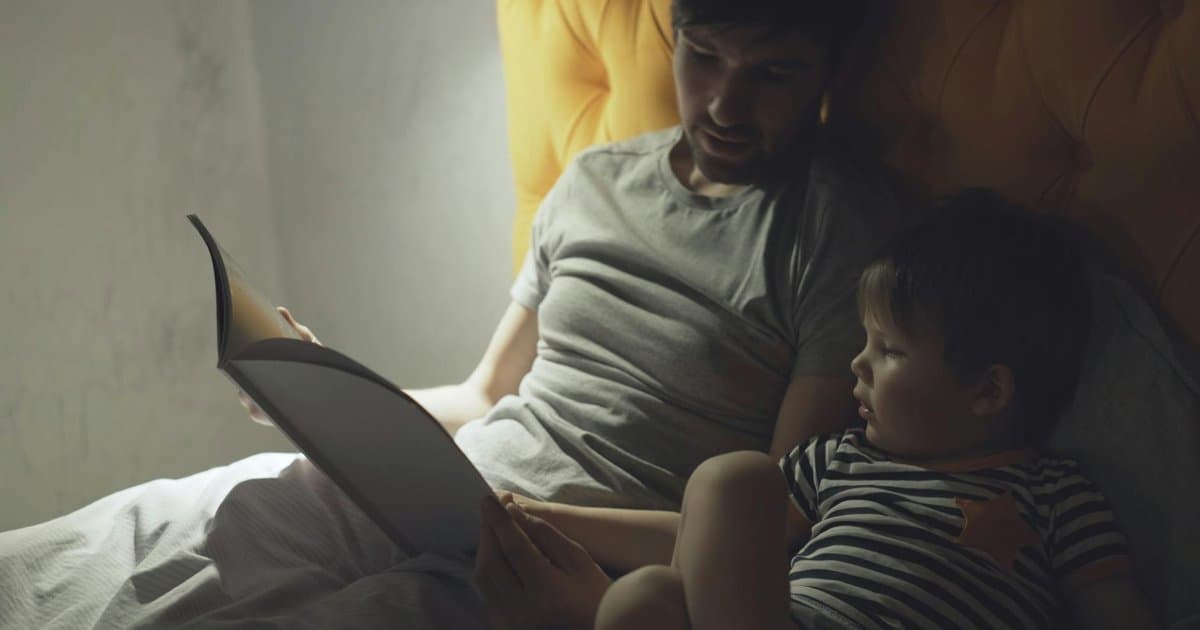 Father reading to young son at bedtime, illustrating storytelling techniques for preschoolers.