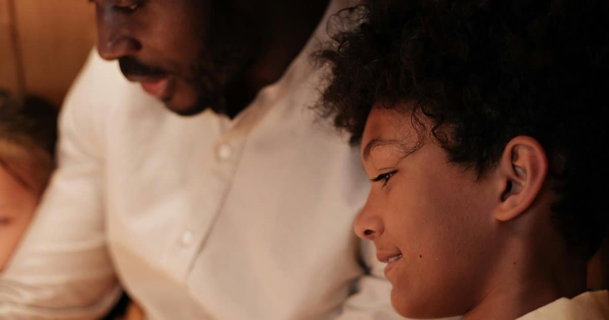 A father and son reading together at home, illustrating meaningful bonding gifts for stepdads.