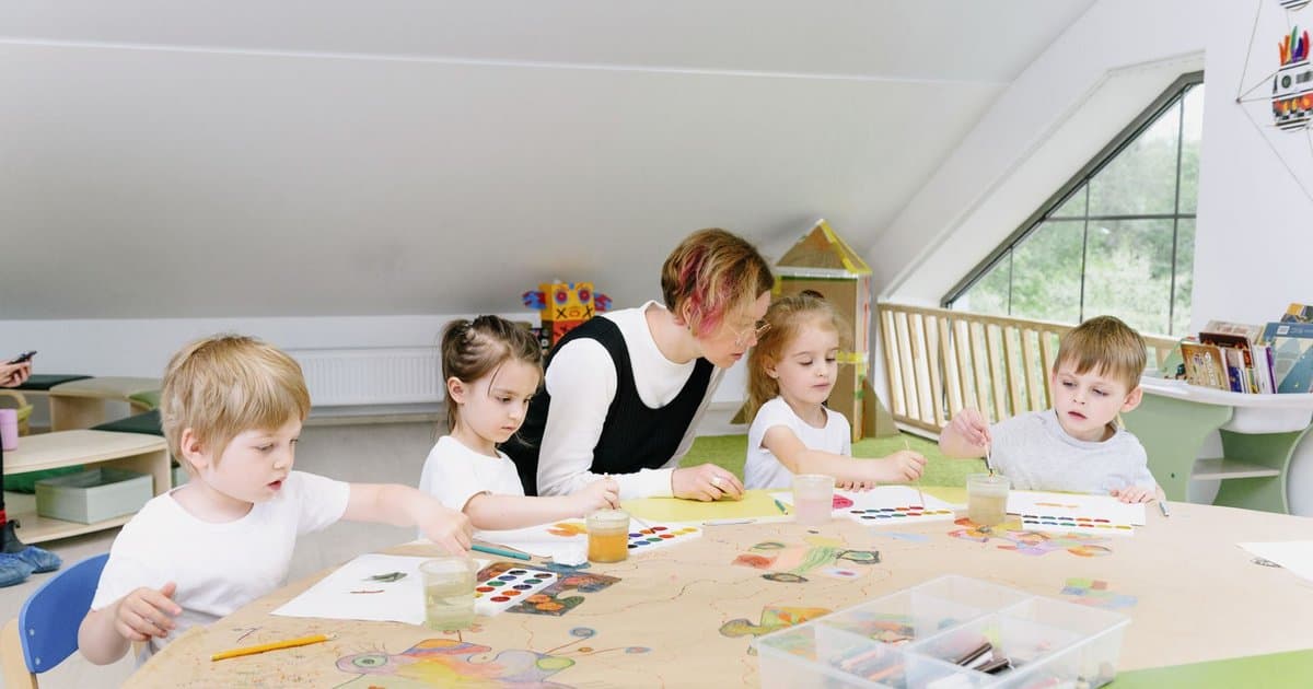 Teacher and young children doing art activities in a classroom, building calm skills for managing anxiety.