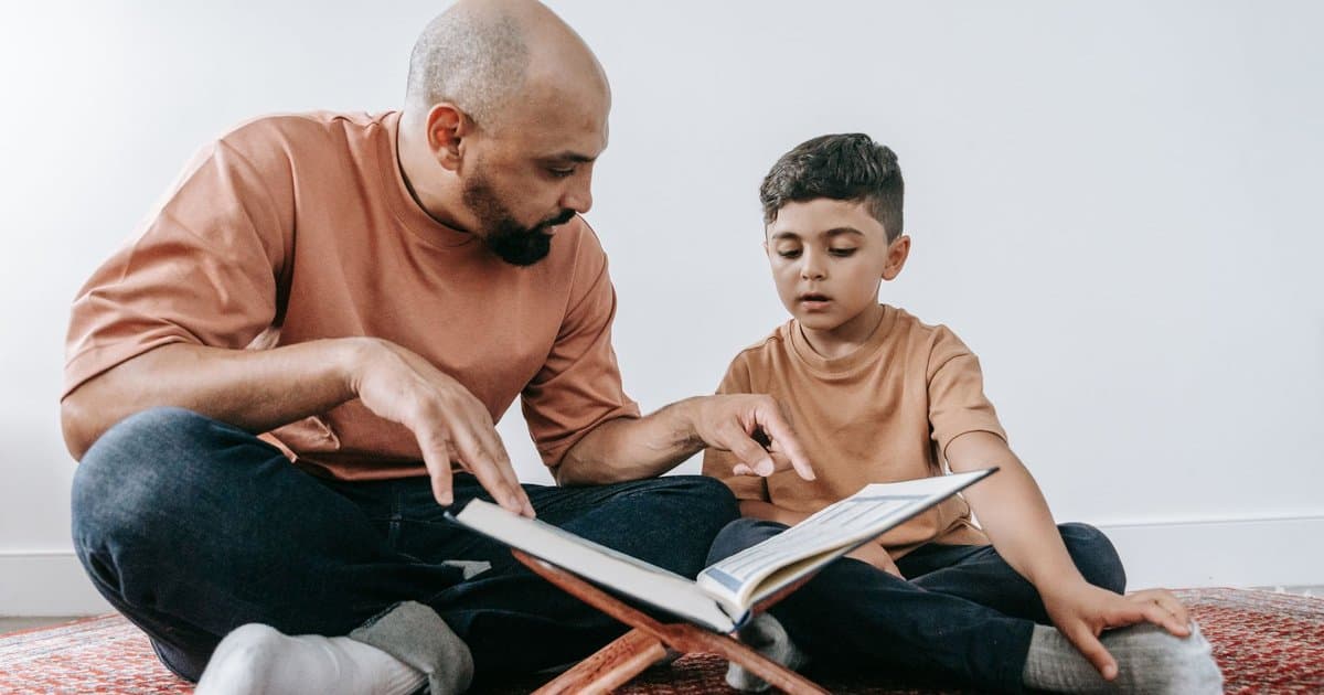 A father and son reading together, illustrating teaching techniques that strengthen learning and connection.