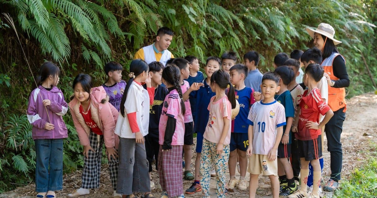 Children and adults on a nature trail learning together during an outdoor field trip activity.
