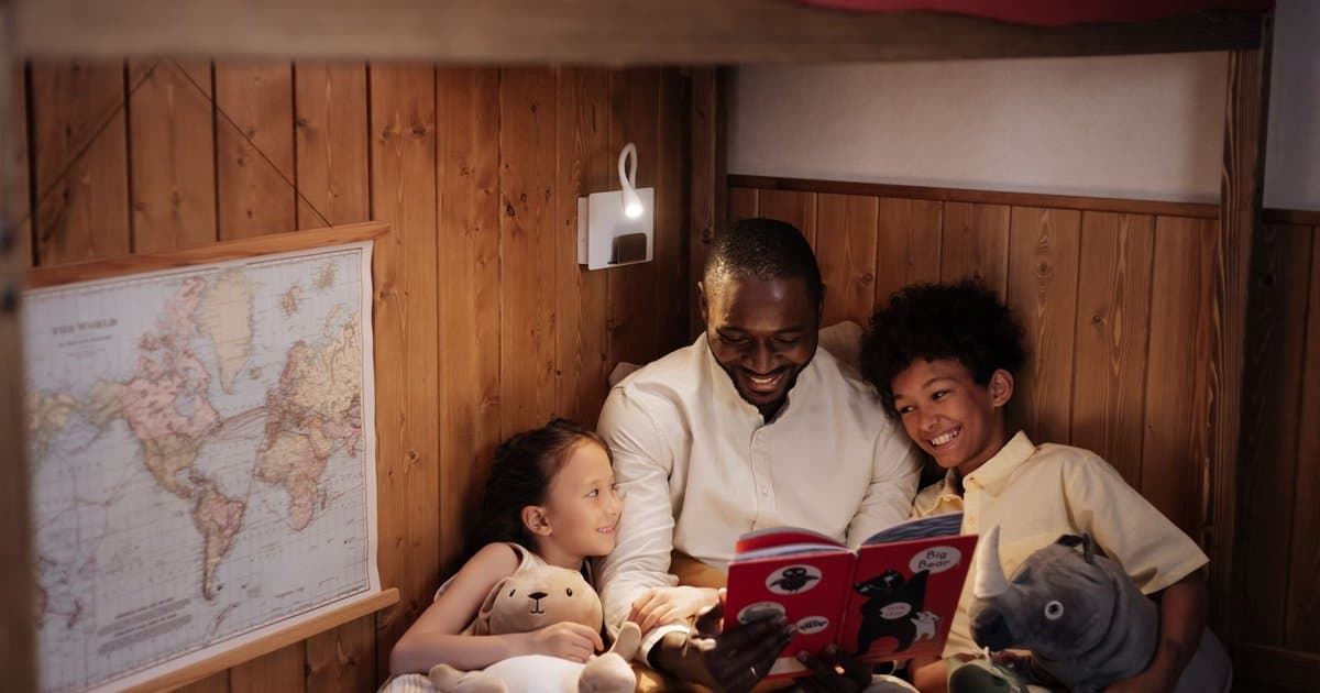A father reads a bedtime story to his children, inspiring imaginative sea adventures and ocean tales.