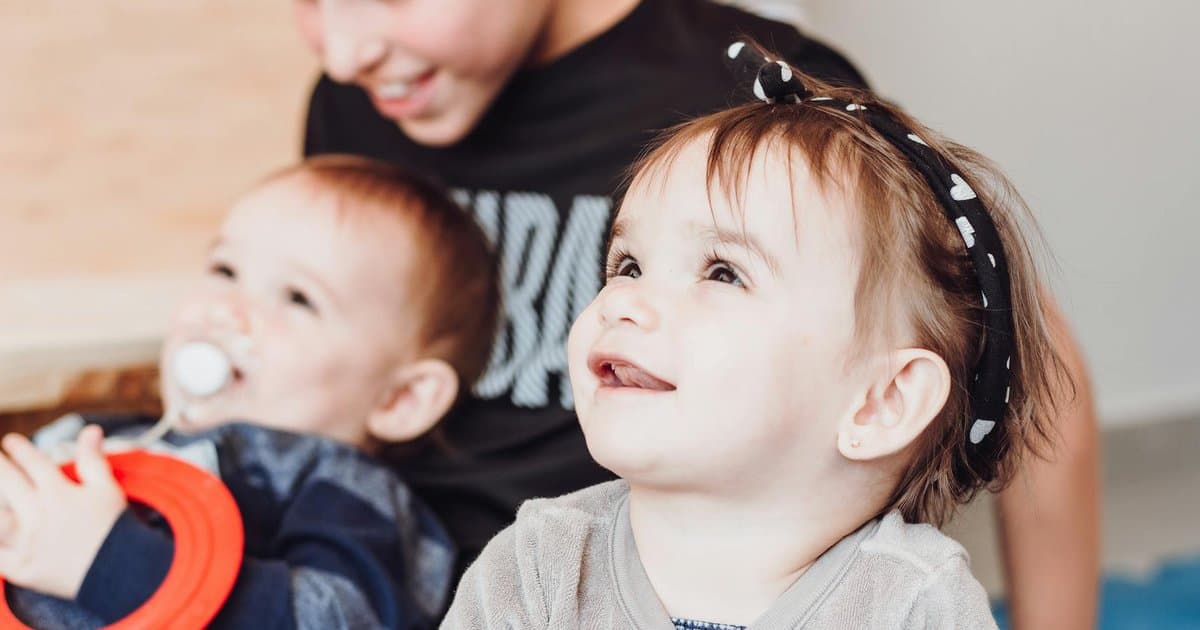 Two young siblings playing together indoors, illustrating positive sibling interactions and conflict management.