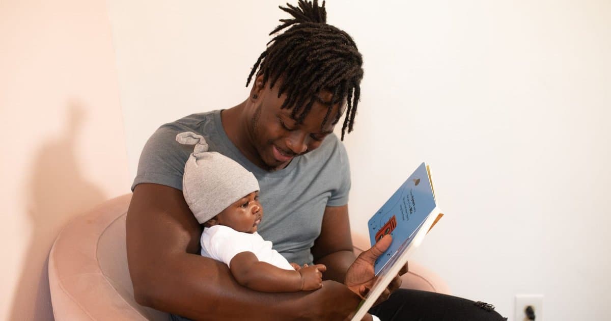Father reading a book to his baby, showing how personalized stories strengthen parent-child bonds.