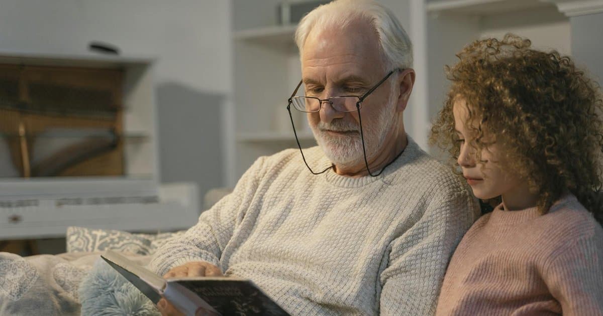 Grandfather and granddaughter reading a personalized book together, showing how custom stories create bonding moments.