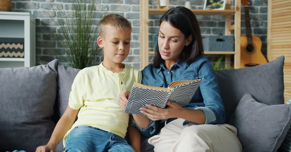 A mother and son reading together on a sofa, illustrating how personalized storybooks engage children.