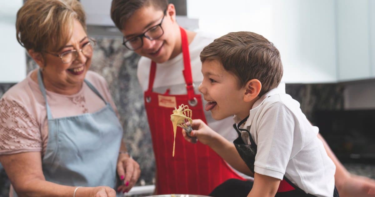 Grandmother and grandsons baking together in a kitchen, preparing traditional dishes for a family celebration.