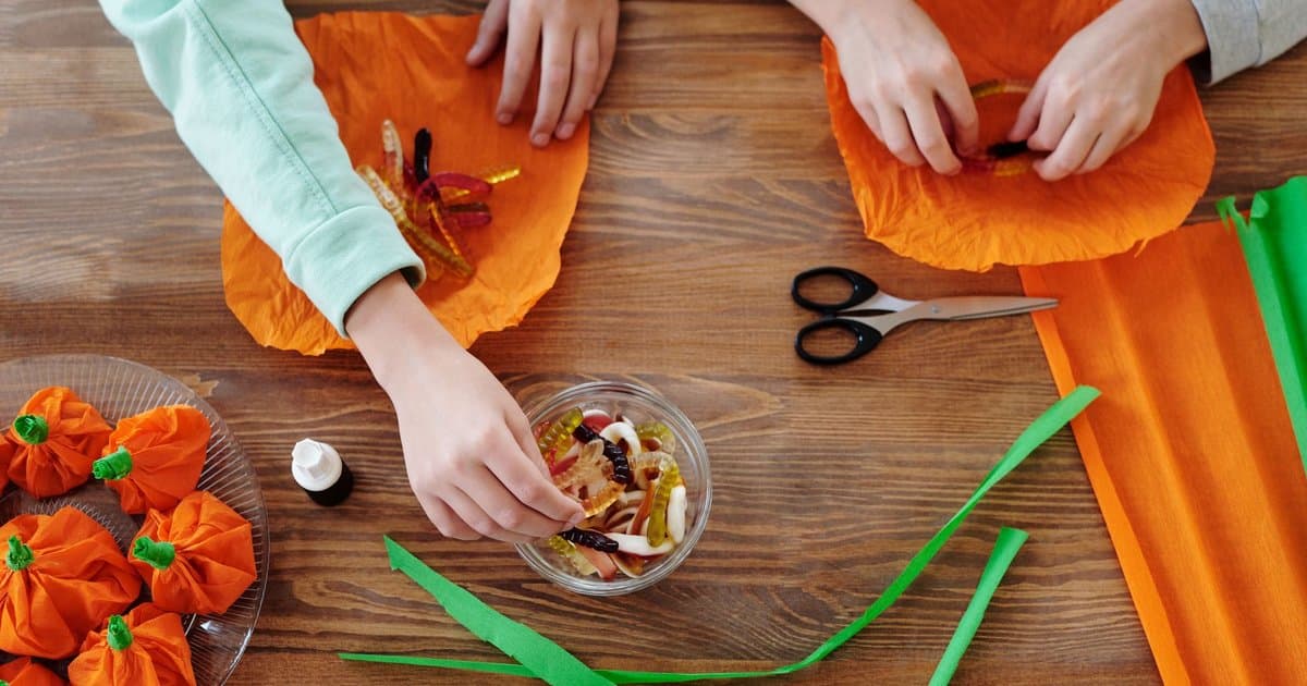 Two children wrap Halloween candies and treats, an example of a classroom activity for the holiday.