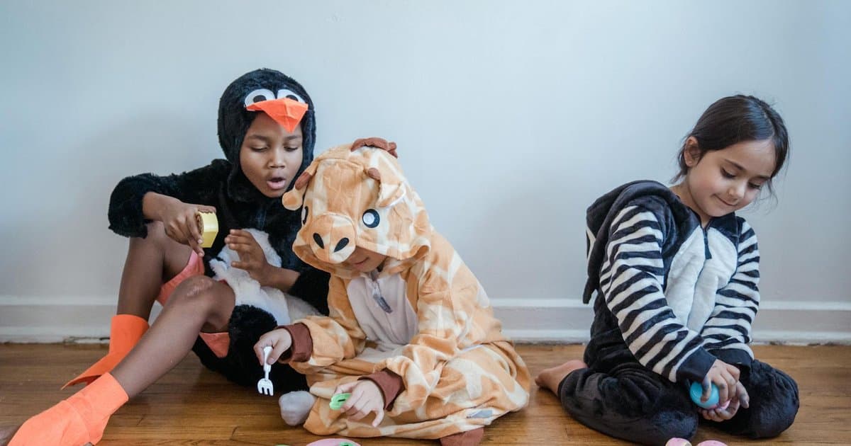 Children in animal costumes playing with toys indoors, representing safari-themed play activities.