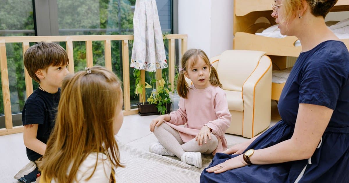 Teacher reading to children in a classroom, illustrating interactive teaching methods used in social stories.