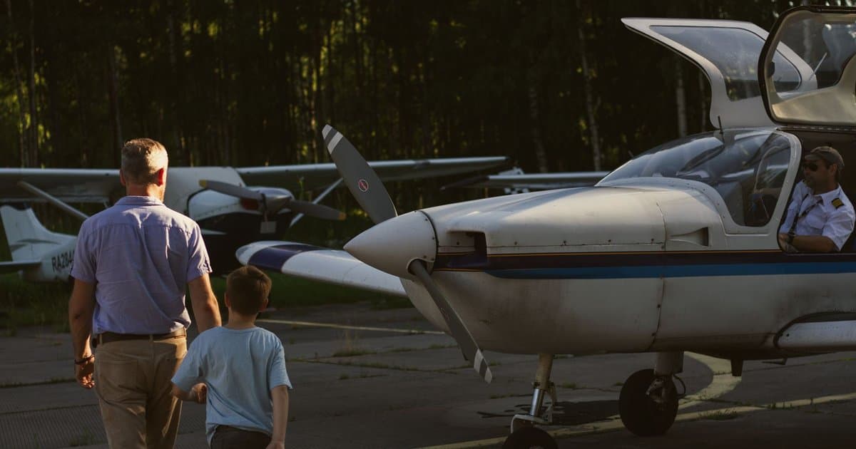 Father and child walking toward a small airplane at an airport, illustrating pre-flight safety preparation.