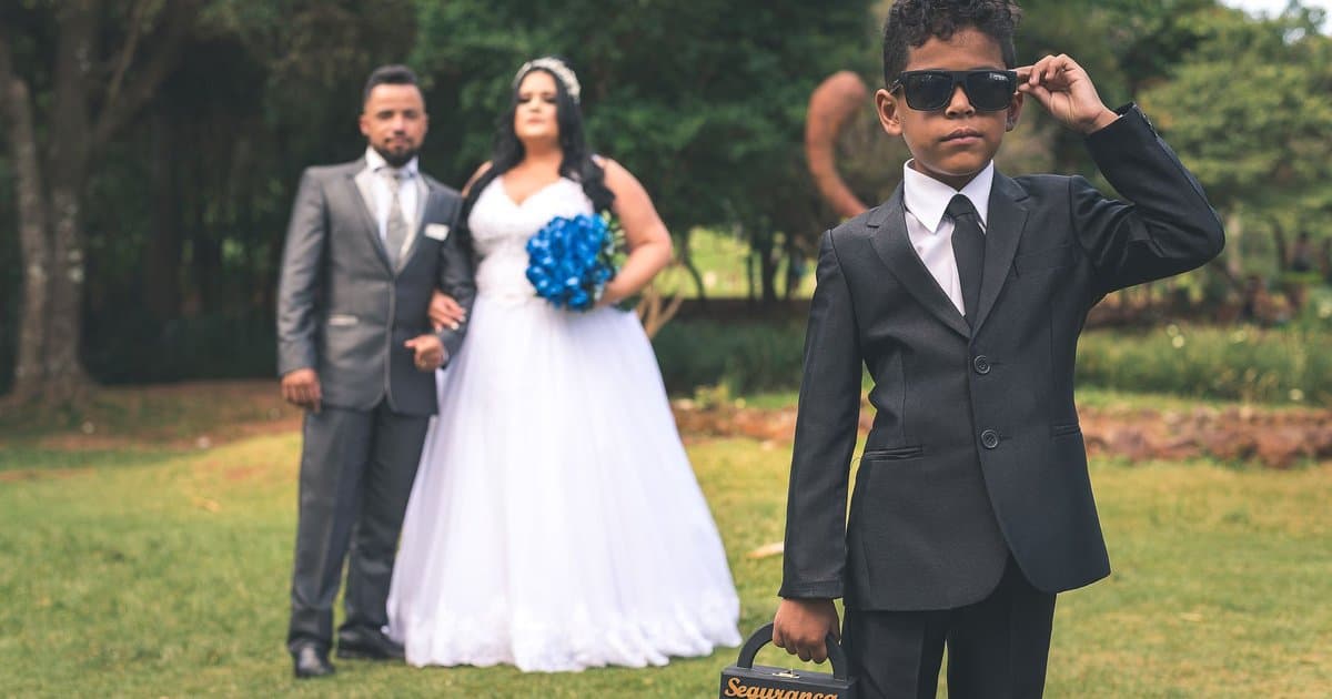 Young ring bearer in formal attire at a wedding ceremony, illustrating proper wedding guest etiquette and roles.